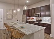 Thumbnail 30 of 40 - a kitchen with a marble counter top at Hunters Creek Apartments, Denton, 76210