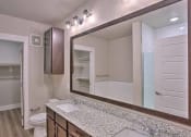 Thumbnail 31 of 40 - a bathroom with a sink and a large mirror at Hunters Creek Apartments, Denton