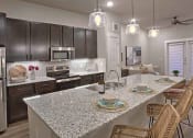 Thumbnail 32 of 40 - a kitchen with a counter and a table at Hunters Creek Apartments, Texas