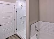 Thumbnail 37 of 40 - a bathroom with a tub and a shower and a door at Hunters Creek Apartments, Denton, 76210