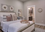 Thumbnail 38 of 40 - a bedroom with a bed and a clock on the wall at Hunters Creek Apartments, Denton, TX 76210