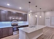 Thumbnail 39 of 40 - a kitchen with a sink and a counter top at Hunters Creek Apartments, Denton, TX
