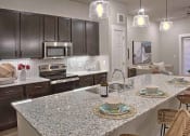 Thumbnail 40 of 40 - a kitchen with stainless steel appliances and a granite counter top at Hunters Creek Apartments, Texas, 76210