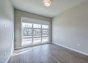 Thumbnail 828 of 885 - A room with a large window and wooden flooring.