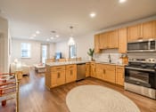 Thumbnail 1 of 9 - A kitchen with wooden cabinets and stainless steel appliances.