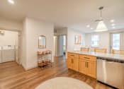 Thumbnail 2 of 9 - A kitchen with wooden floors and white walls.