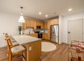 Thumbnail 4 of 9 - A kitchen with wooden cabinets and a white island.