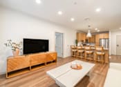 Thumbnail 7 of 9 - A modern living room with a flat screen TV and a dining area.