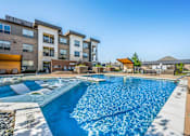 Thumbnail 4 of 56 - A large swimming pool in front of apartment buildings.