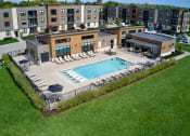 Thumbnail 1 of 36 - an aerial view of a pool with chairs and a building at Statesman Apartments, Franklin, 53132