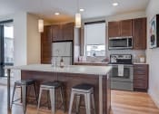 Thumbnail 6 of 36 - a kitchen with a center island with three stools at Statesman Apartments, Franklin
