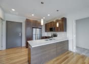 Thumbnail 12 of 36 - a kitchen with a large island and a stainless steel refrigerator at Statesman Apartments, Wisconsin