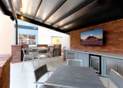 Thumbnail 13 of 52 - a patio with a table and chairs and a tv at Aster Apartments, Beachwood, OH