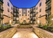 Thumbnail 26 of 52 - a courtyard with a stone wall in the middle of an apartment building at Aster Apartments, Beachwood, OH 44122