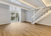 Thumbnail 18 of 28 - an empty living room with stairs and a door to a balcony at Park 44, St. Louis