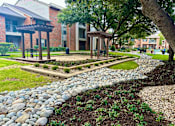 Thumbnail 12 of 44 - a garden with rocks and a stone path at Wellington at Willow Bend Apartments, Plano