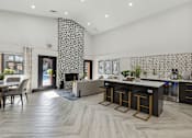 Thumbnail 3 of 44 - a living room with a kitchen and a fireplace at Wellington at Willow Bend Apartments, Plano, TX, 75093