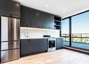Thumbnail 18 of 29 - A modern kitchen with dark wood cabinets and stainless steel appliances.