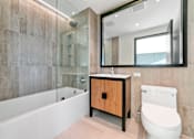 Thumbnail 14 of 29 - A modern bathroom with a wooden cabinet and a white toilet.