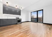 Thumbnail 16 of 29 - A kitchen with wooden floors and a large window.