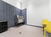 Thumbnail 9 of 29 - A room with a blue brick wall and a yellow chair.