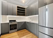 Thumbnail 11 of 29 - A modern kitchen with a stainless steel refrigerator and a built-in oven.