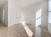 Thumbnail 2 of 7 - an empty living room with white walls and wood floors