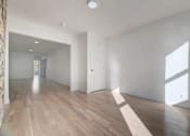 Thumbnail 1 of 7 - an empty living room and hallway with white walls and wood floors