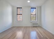 Thumbnail 3 of 7 - an empty living room with a radiator and two windows