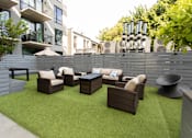 Thumbnail 14 of 37 - Outdoor patio lounge with artificial turf and wicker seating at 1134 Fulton Street Apartments, Brooklyn, New York