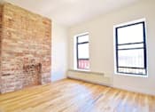 Thumbnail 2 of 5 - A room with a brick fireplace and wooden floors.