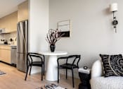 Thumbnail 30 of 56 - a living room with a small table and a kitchen at The Paxton, Brooklyn, 11201