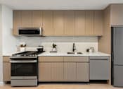 Thumbnail 32 of 56 - a kitchen with wooden cabinets and stainless steel appliances at The Paxton, New york