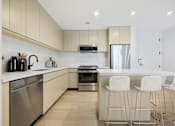 Thumbnail 36 of 56 - a kitchen with white cabinets and a island with three stools at The Paxton, Brooklyn, NY 11201