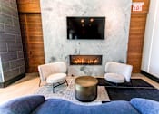 Thumbnail 11 of 56 - A living room with a fireplace and a flat screen TV mounted on the wall.