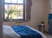 Thumbnail 11 of 42 - a bedroom with a bed and a window at The 22 Apartments, St. Louis, 63103