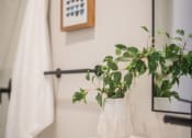 Thumbnail 9 of 42 - a bathroom with a white sink and a plant in a white vase at The 22 Apartments, St. Louis