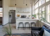 Thumbnail 30 of 42 - a kitchen with a large window and a white island with a white countertop at The 22 Apartments, Missouri, 63103