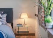 Thumbnail 12 of 42 - a nightstand with a lamp on it next to a bed at The 22 Apartments, St. Louis Missouri