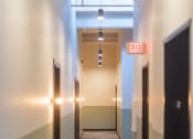 Thumbnail 38 of 42 - a long corridor with black doors and white walls at The 22 Apartments, St. Louis, MO