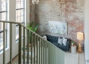 Thumbnail 4 of 42 - a living room with a brick wall and a couch in front of it at The 22 Apartments, Missouri