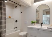 Thumbnail 41 of 42 - a bathroom with a white sink and toilet next to a white bathtub at The 22 Apartments, Missouri