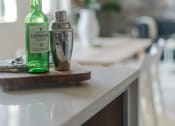 Thumbnail 15 of 42 - a bottle of liquor and a cocktail shaker sit on a kitchen counter at The 22 Apartments, St. Louis Missouri
