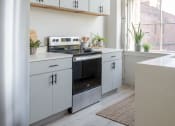 Thumbnail 39 of 42 - a kitchen with white cabinets and a wood floor at The 22 Apartments, St. Louis, 63103