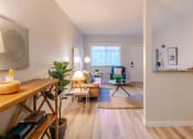 Thumbnail 5 of 11 - a living room with white walls and wooden floors and a dining room table