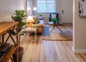 Thumbnail 9 of 11 - a living room with wooden floors and a couch and a table