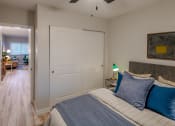 Thumbnail 3 of 11 - a bedroom with a bed and a door to a living room