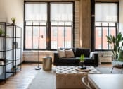 Thumbnail 2 of 28 - a living area with a couch coffee table and large windows at The Draper, Missouri