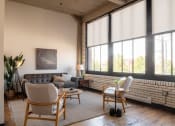 Thumbnail 3 of 28 - a living room with large windows and a brick wall at The Draper, Missouri