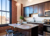 Thumbnail 20 of 42 - a kitchen with brown cabinets and a large window at The 22 Apartments, St. Louis Missouri